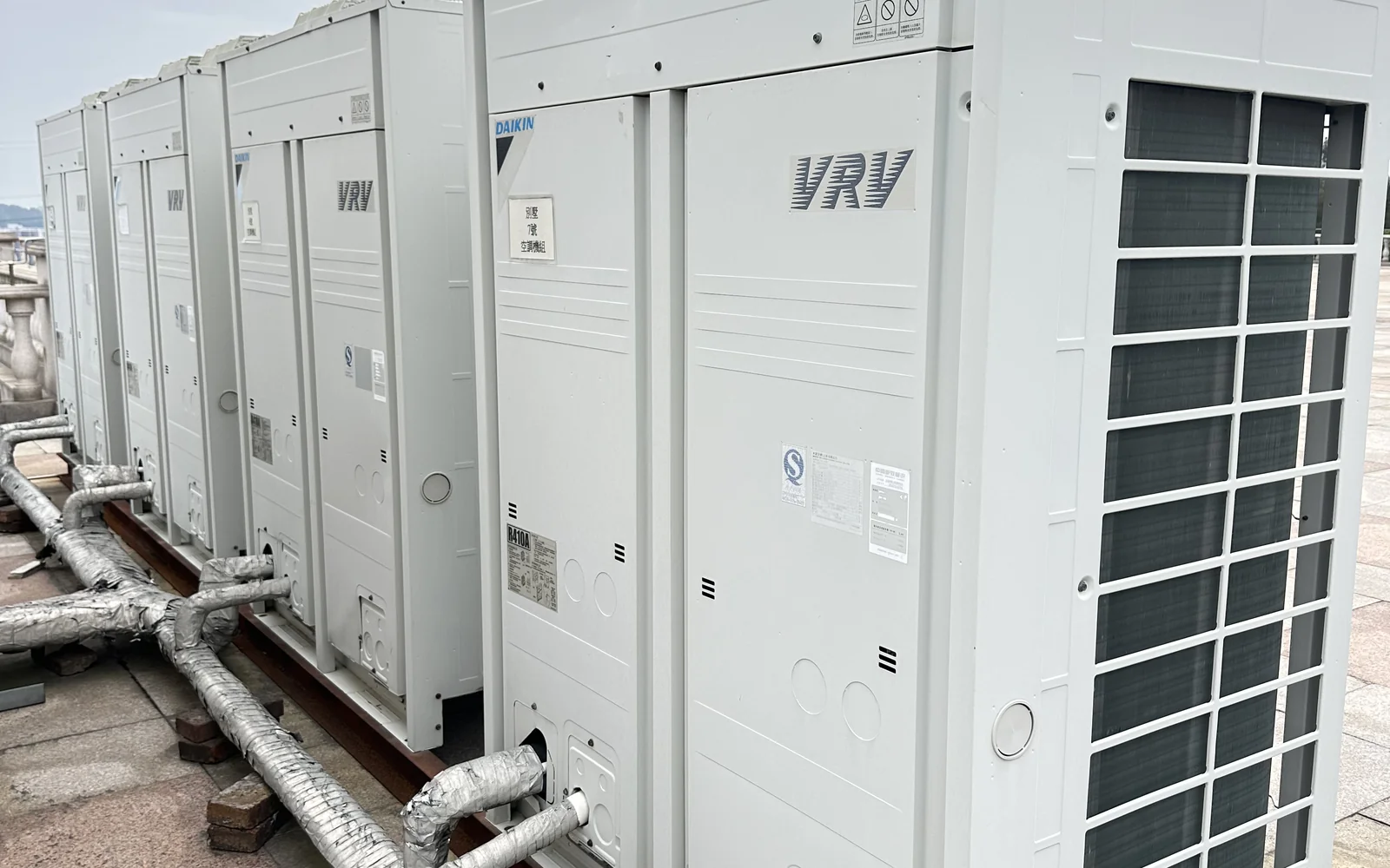 项目现场成排多联机（VRV）室外机组实拍 · 侧向进风格栅与冷媒管路